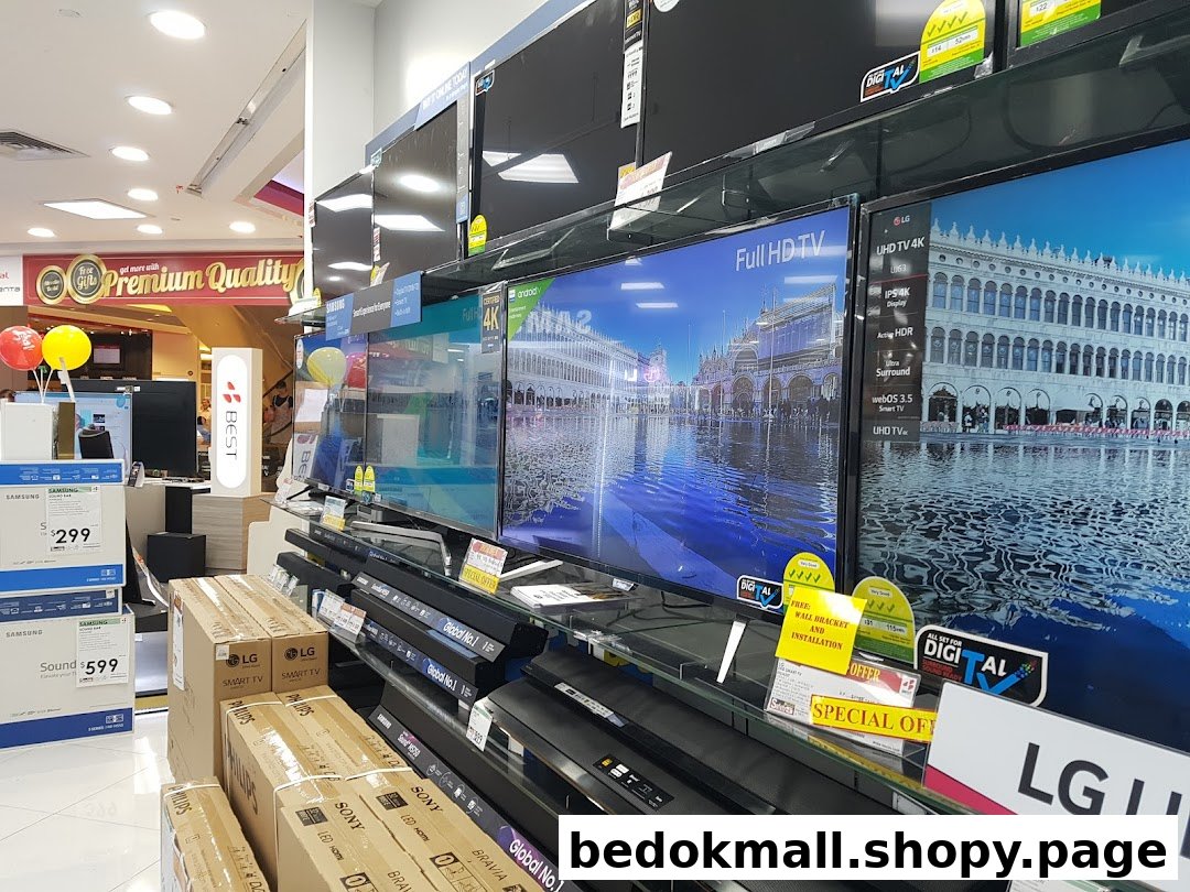 Interior of an electronics store displaying televisions, soundbars, and product boxes.
