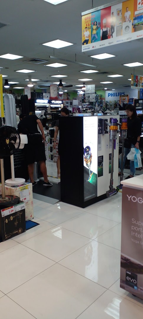 Interior view of an electronics store with customers and various products on display.