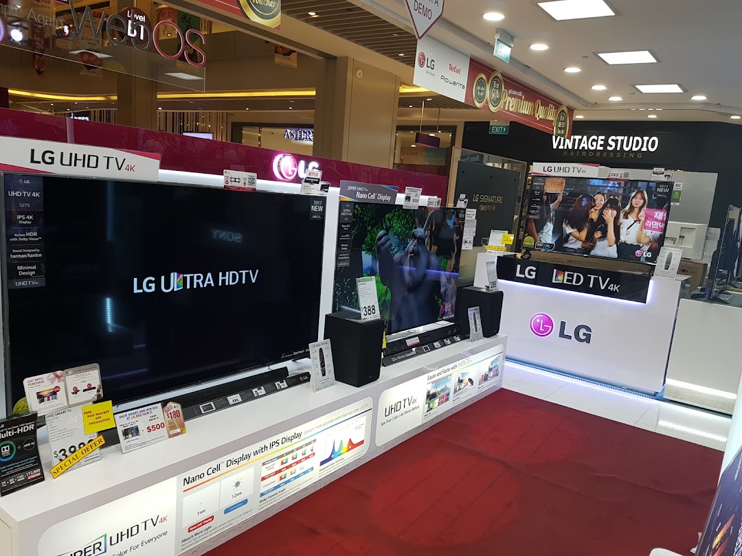 Interior view of an electronics store displaying LG televisions and other products.