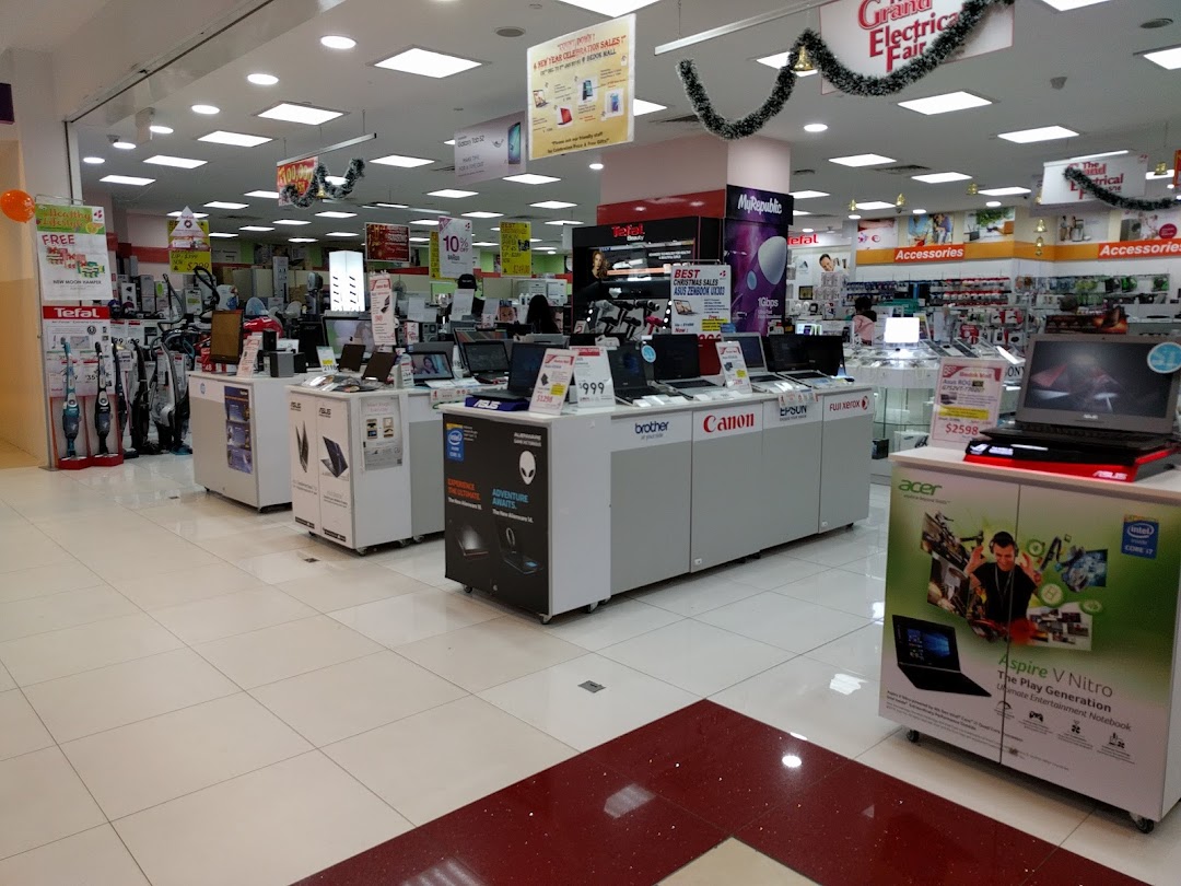 Interior view of an electronics store displaying laptops, home appliances, and accessories.