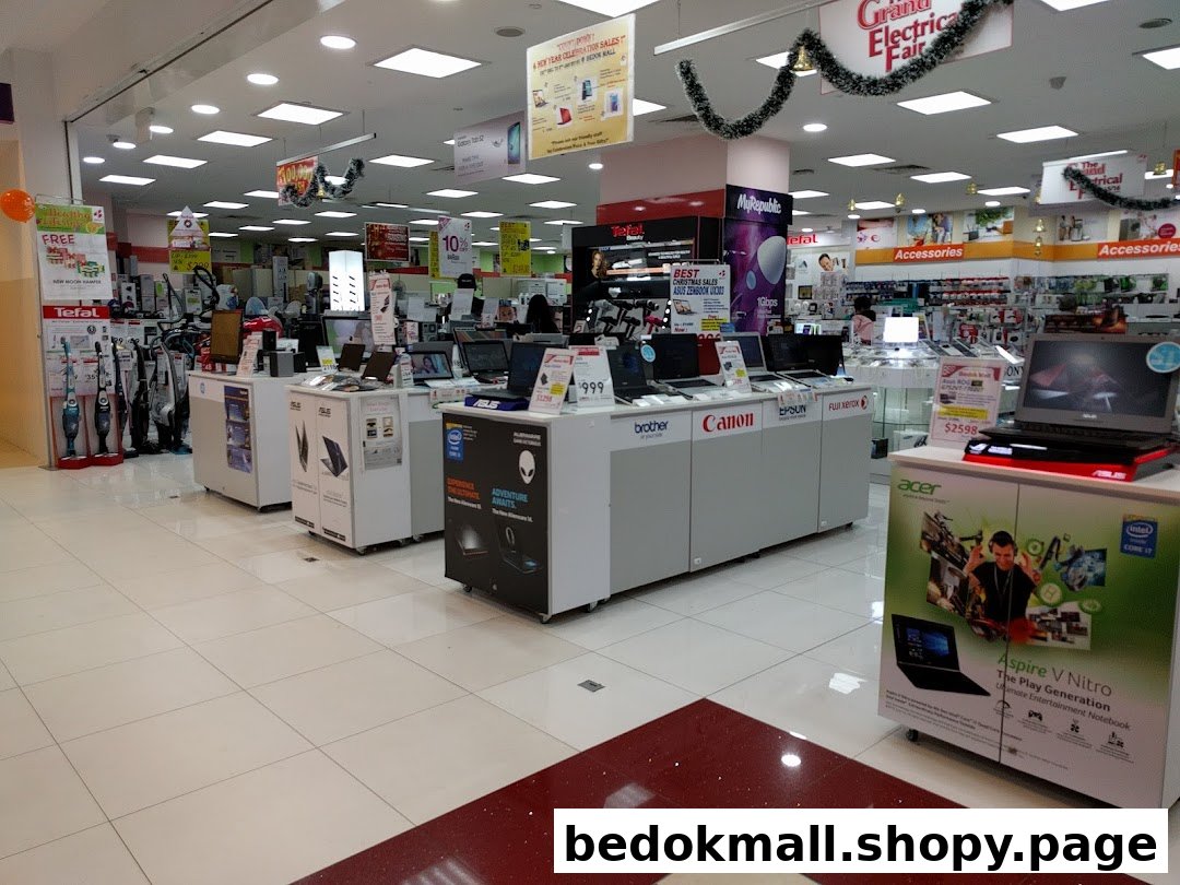 Interior view of an electronics store displaying laptops, home appliances, and accessories.