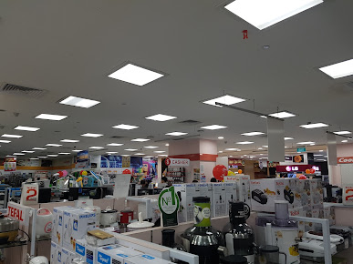 Interior view of a large electronics and home appliance store with various products on display.