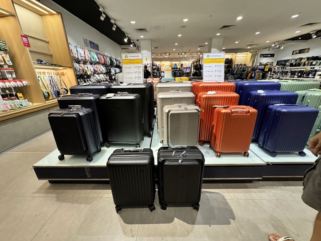 Interior view of a shop displaying various suitcases and travel accessories.