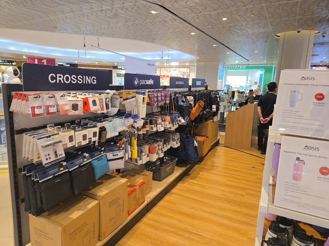 Interior view of a retail shop displaying travel accessories and bottles on shelves.