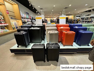 Interior view of a shop displaying various colorful suitcases and luggage.