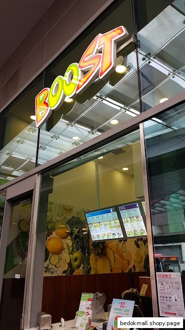 Exterior view of Boost Juice shop with prominent sign and glass entrance.