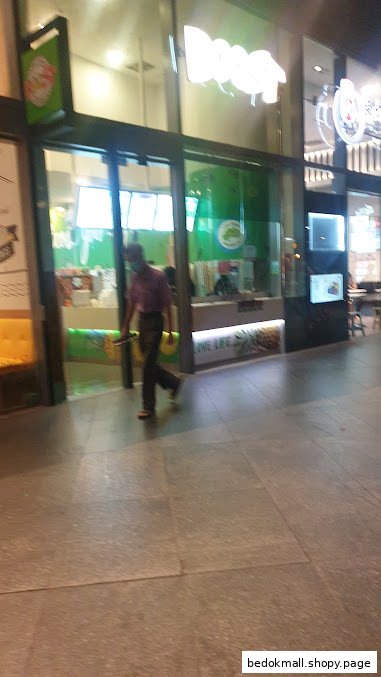 Exterior view of Boost Juice shop with a person walking past.