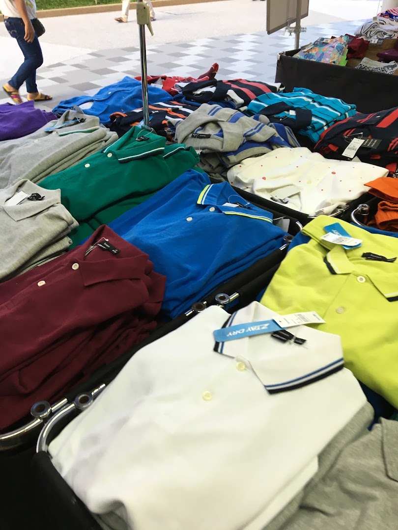 Colorful polo shirts are neatly folded and displayed on a retail table.
