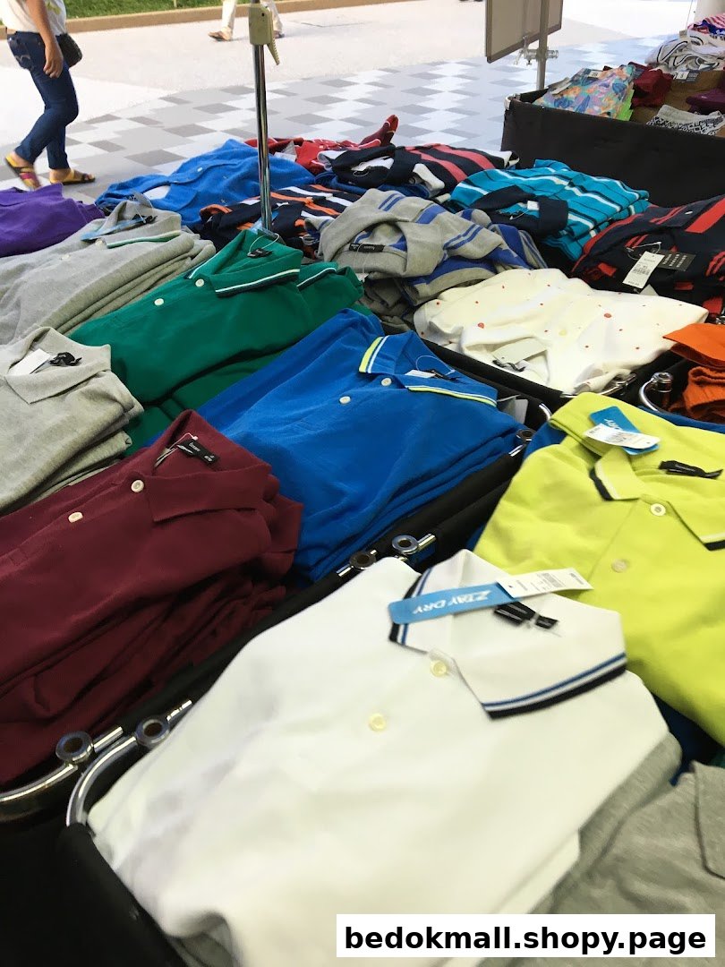 Colorful polo shirts are neatly folded and displayed on a retail table.