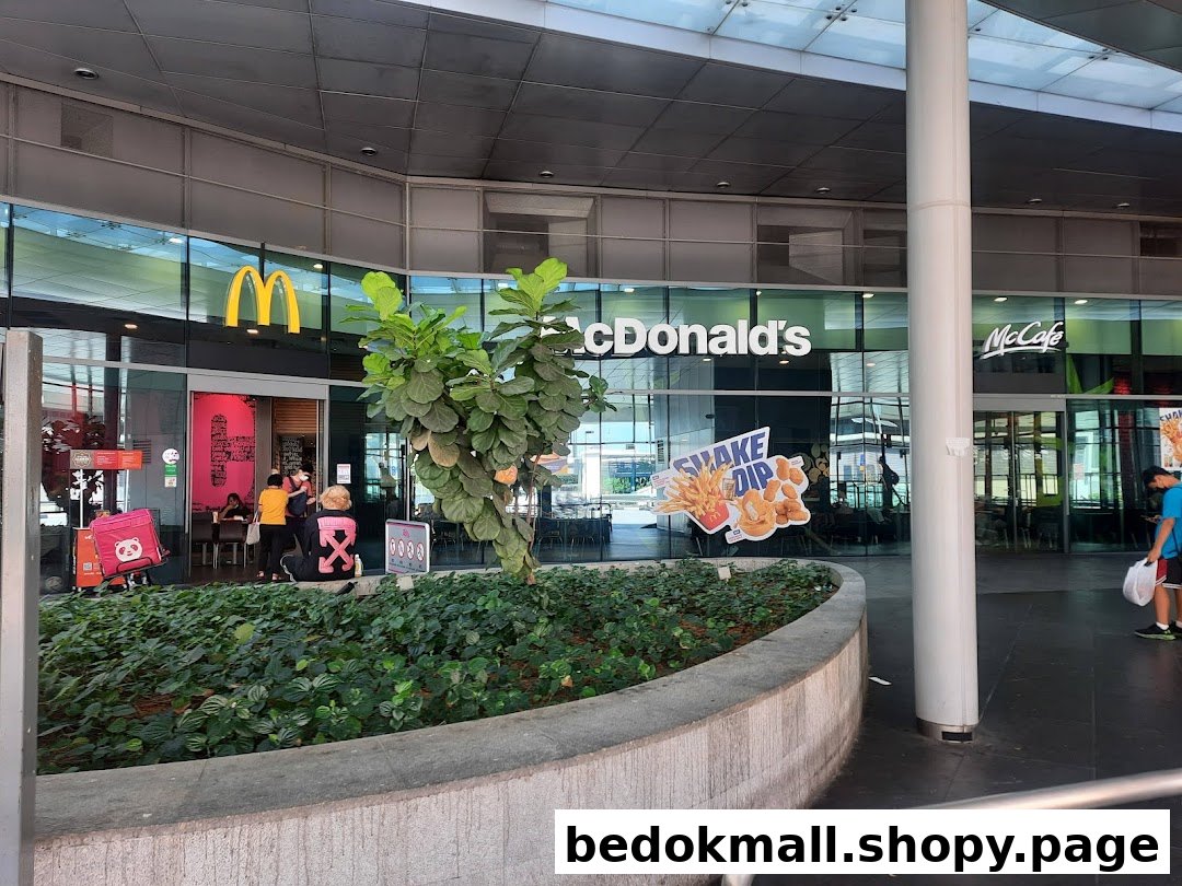 Exterior view of McDonald's restaurant with entrance, signage, and people.