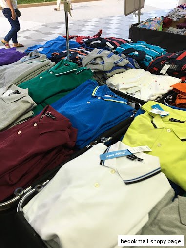 Colorful polo shirts displayed on a table, possibly an outdoor sale.