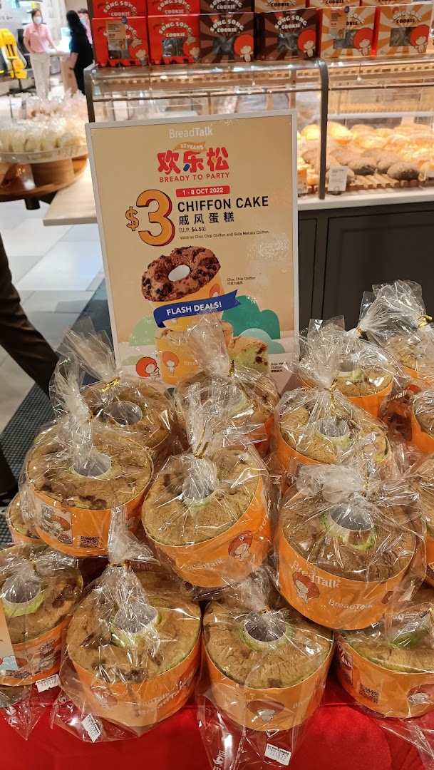 Bakery display of packaged chiffon cakes and a promotional sign.