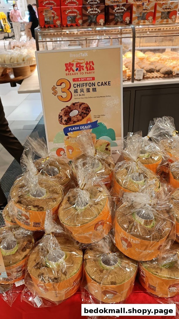 Bakery display of packaged chiffon cakes and a promotional sign.