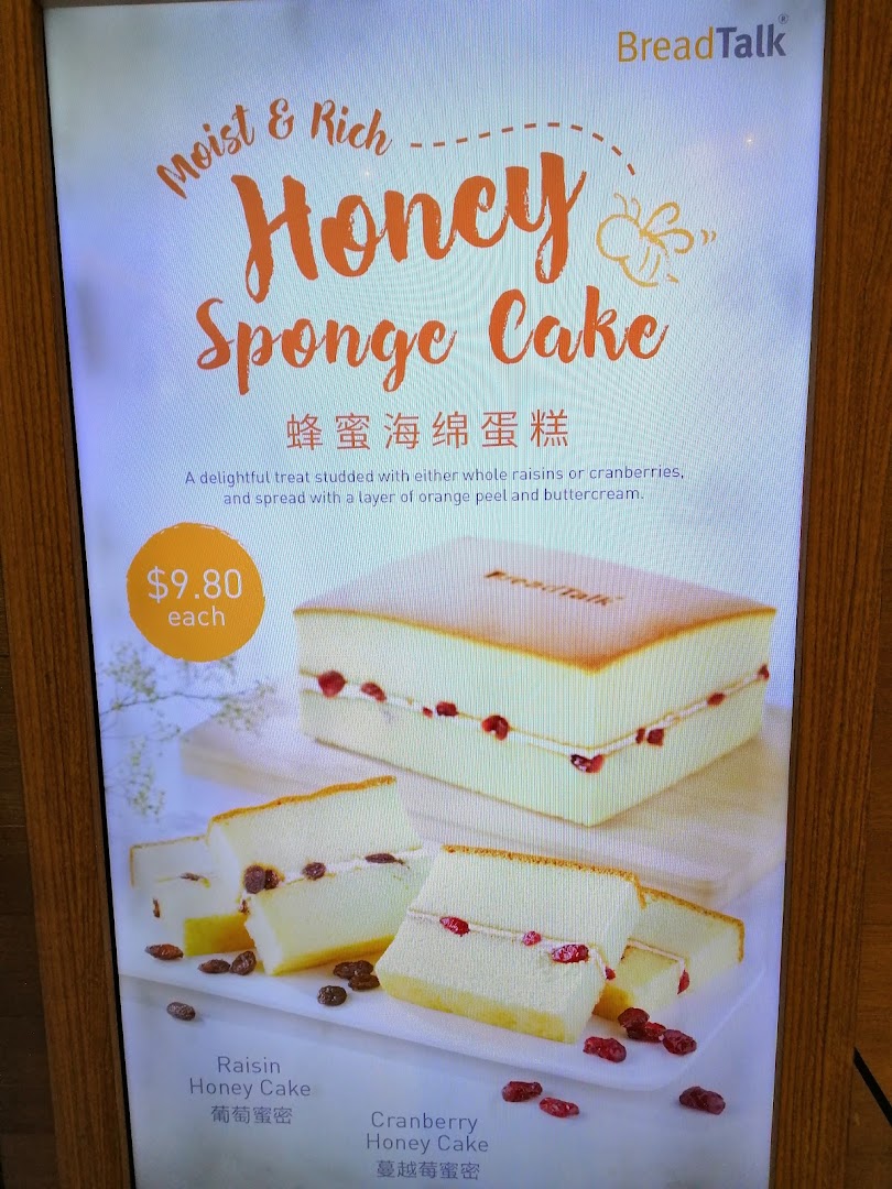 A display board advertising Honey Sponge Cake with price and variations.