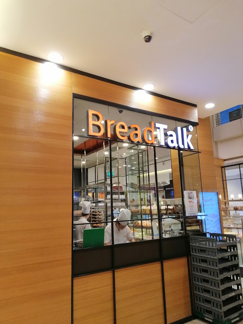 Shop front of BreadTalk bakery with staff and products visible through the window.