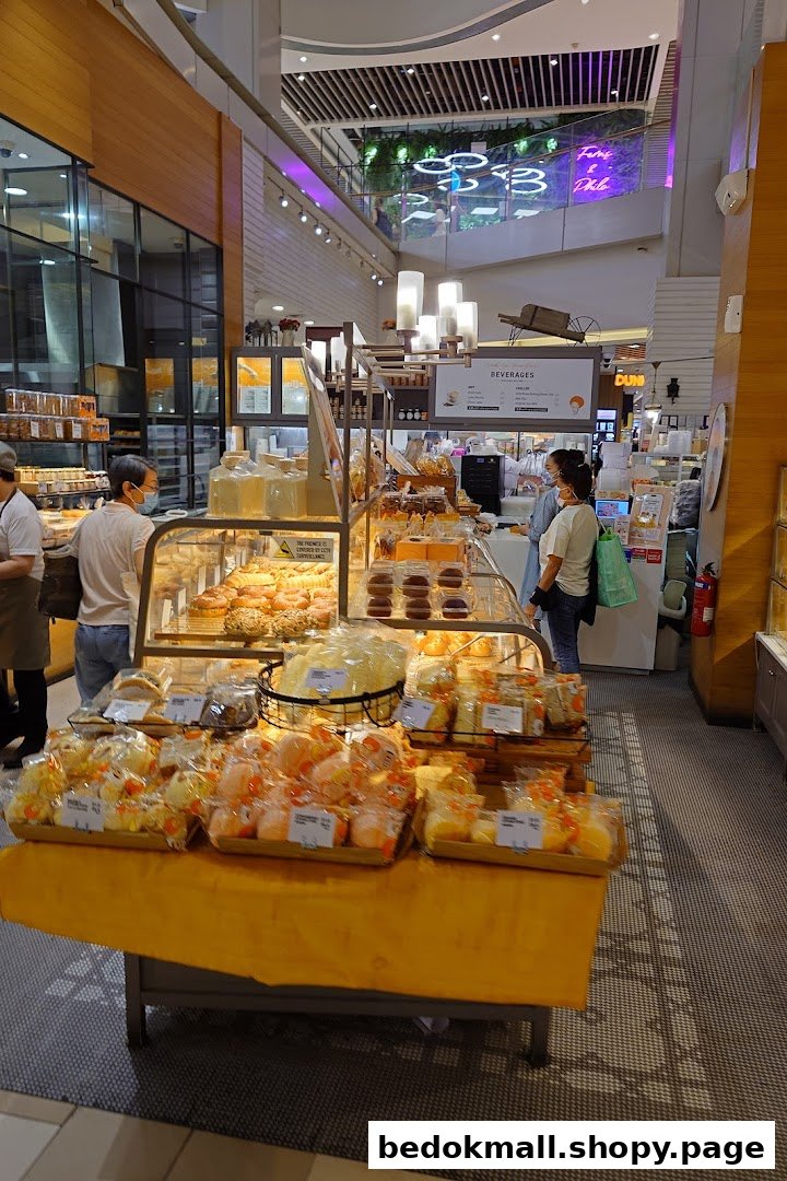 Interior view of a bakery with various baked goods on display and customers.