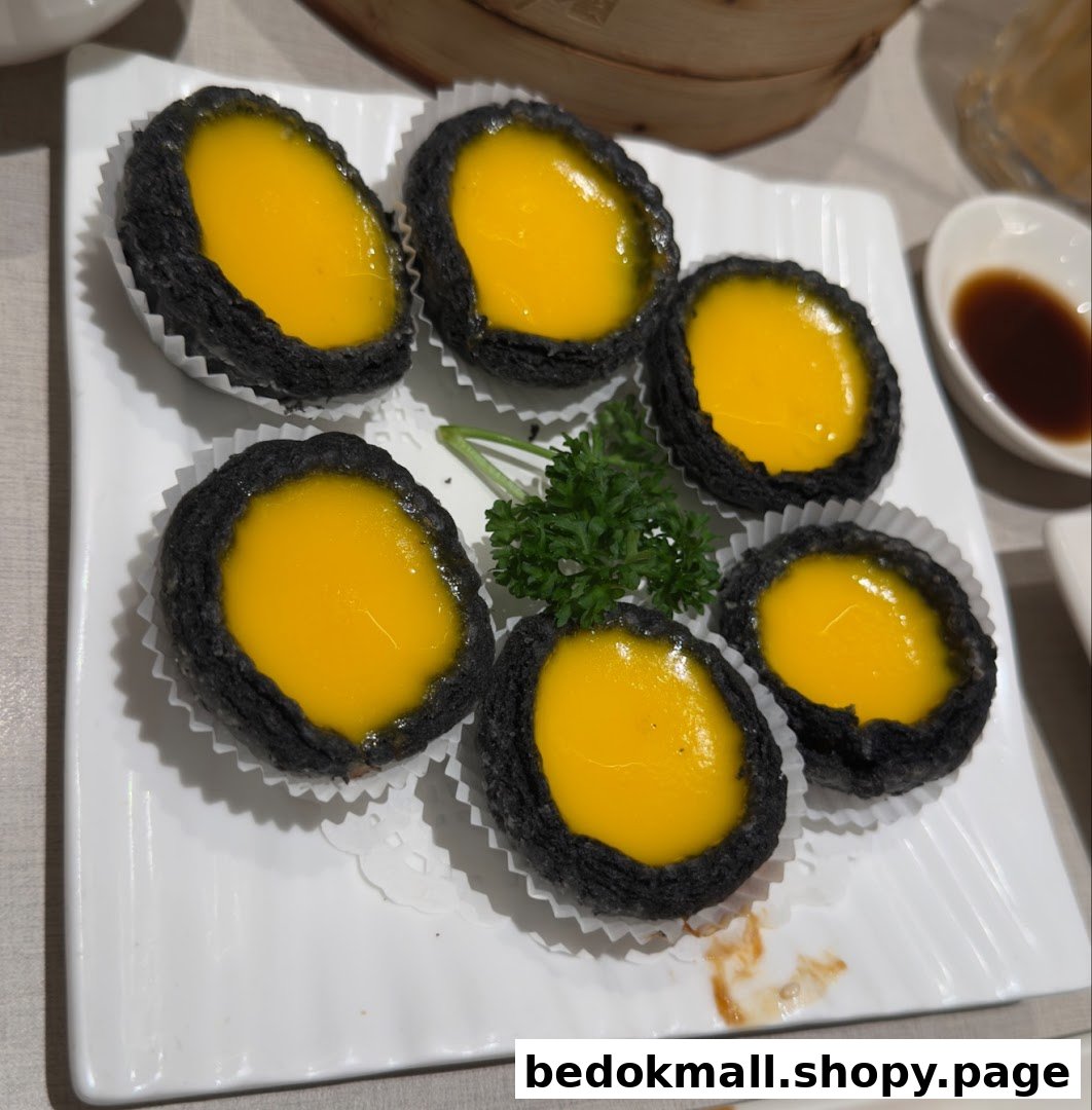 Six black-crusted tarts with yellow filling on a white plate.