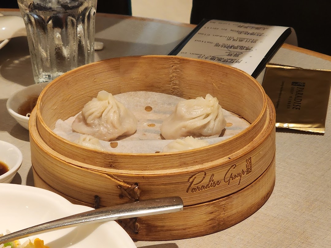 Steamed dumplings in a bamboo steamer on a table.