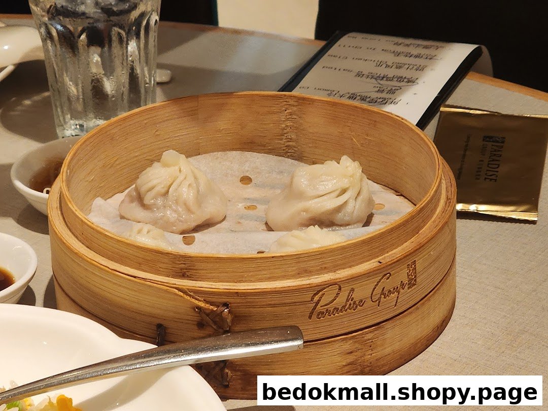 Steamed dumplings in a bamboo steamer on a table.