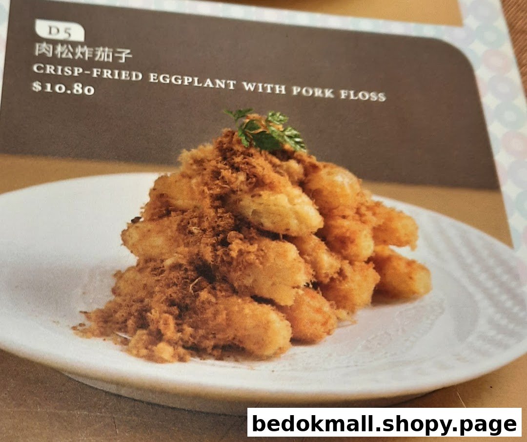 Menu showing crisp-fried eggplant with pork floss on a white plate.