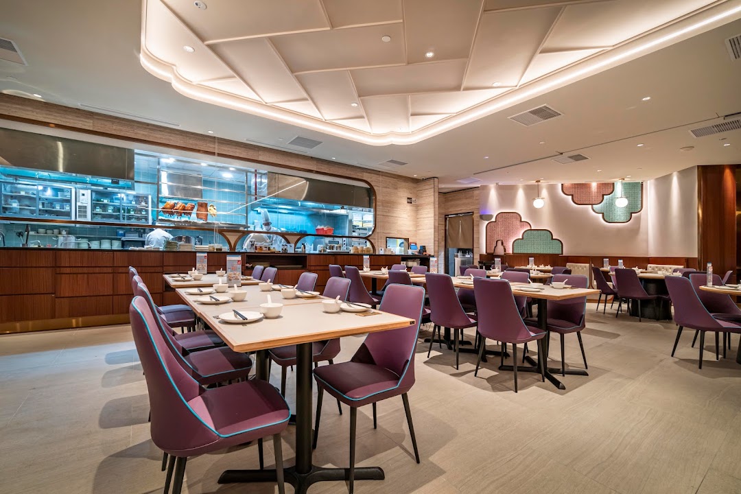 Interior view of a modern restaurant with dining tables and an open kitchen.