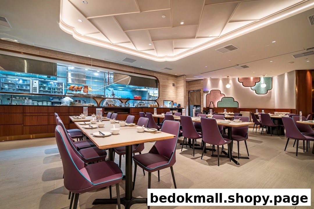 Interior view of a modern restaurant with dining tables and an open kitchen.
