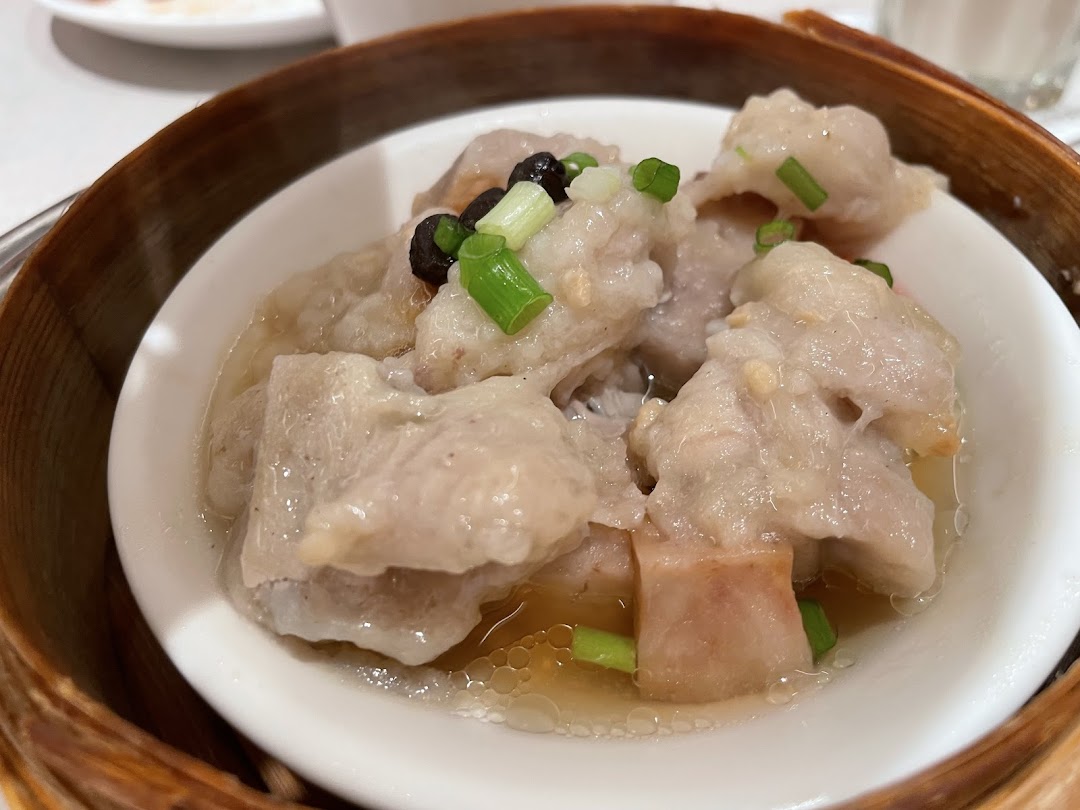 Steamed dish with meat, green onions, and black beans in a bamboo steamer.