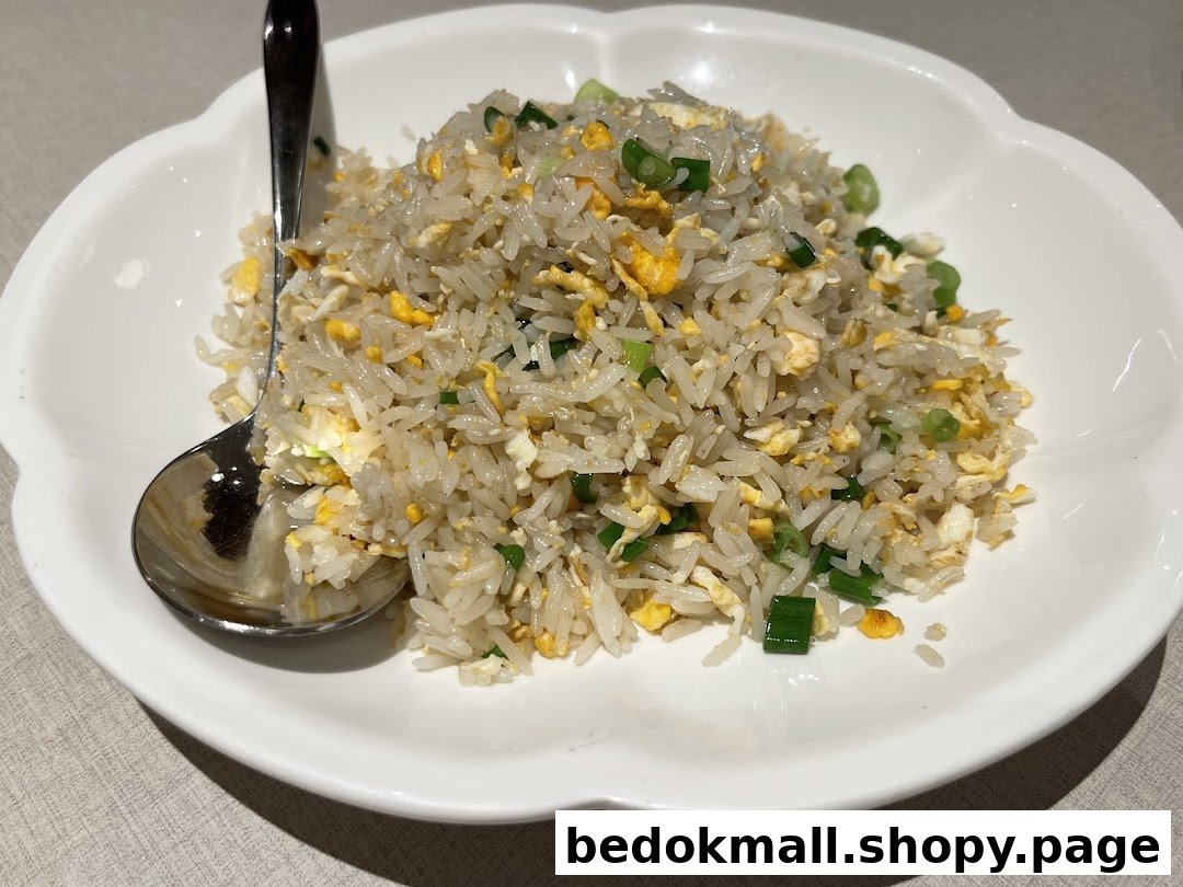 A plate of fried rice with egg and green onions, and a spoon.