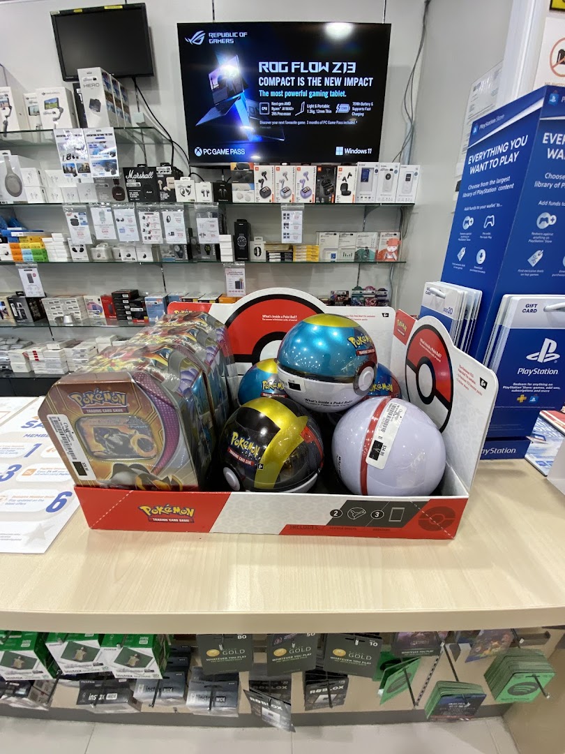 Interior view of a retail store displaying electronics, gaming products, and Pokémon items.