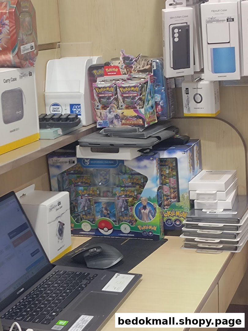 Interior shot of a retail display with Pokémon products, phone accessories, and a laptop.