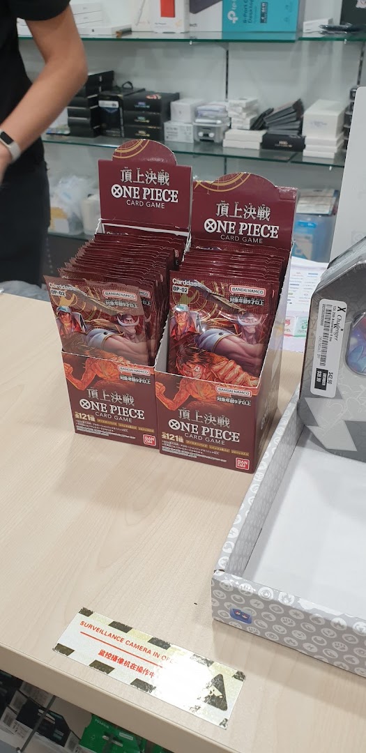 Display of One Piece Card Game booster packs on a shop counter.