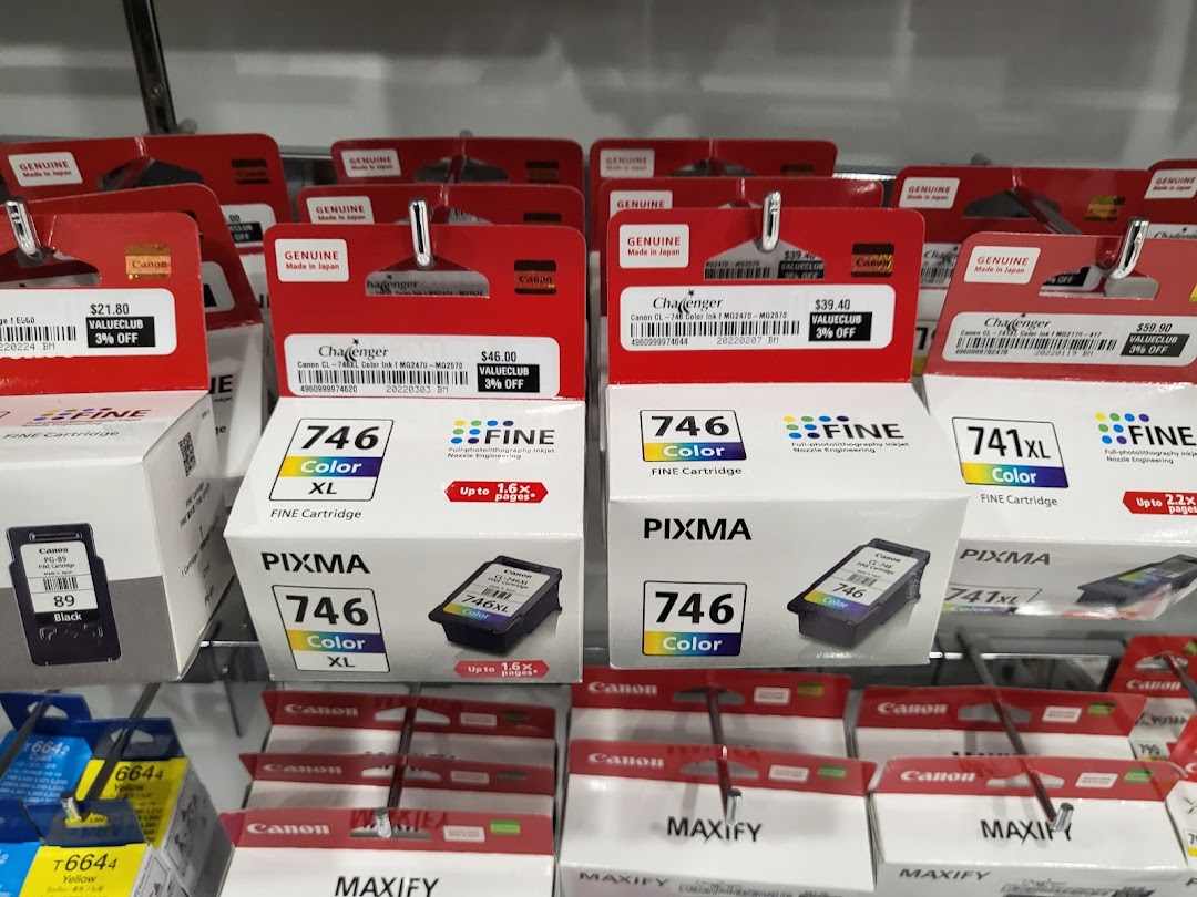 Shelves filled with various Canon printer ink cartridges for sale.