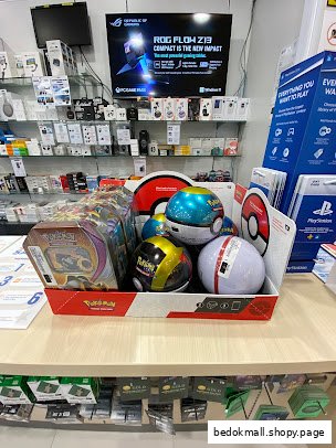 Interior view of an electronics shop with a prominent Pokémon product display.