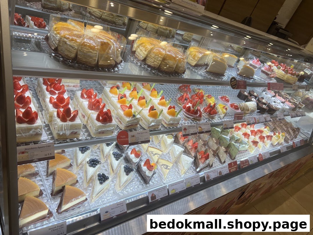 A refrigerated display case filled with various cakes and pastries.
