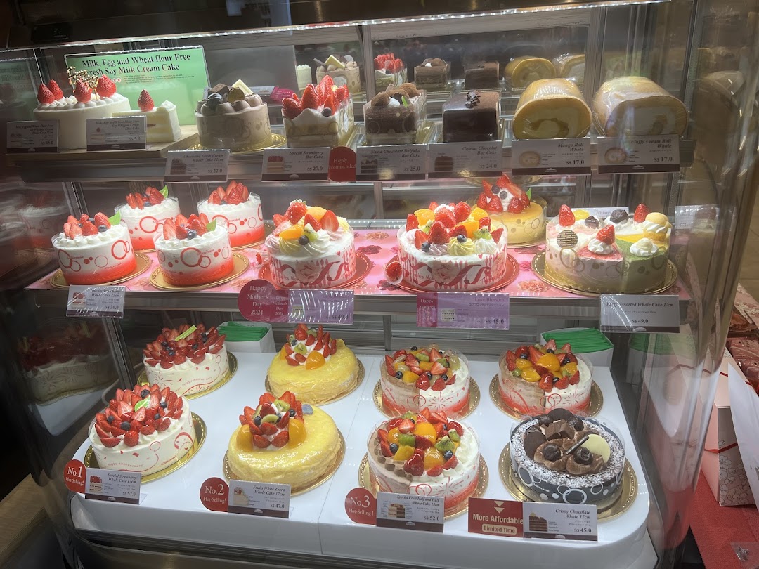 A display case filled with various cakes and pastries.