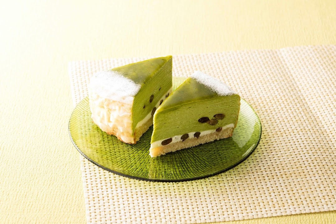 Two slices of green cake on a green plate with a textured background.