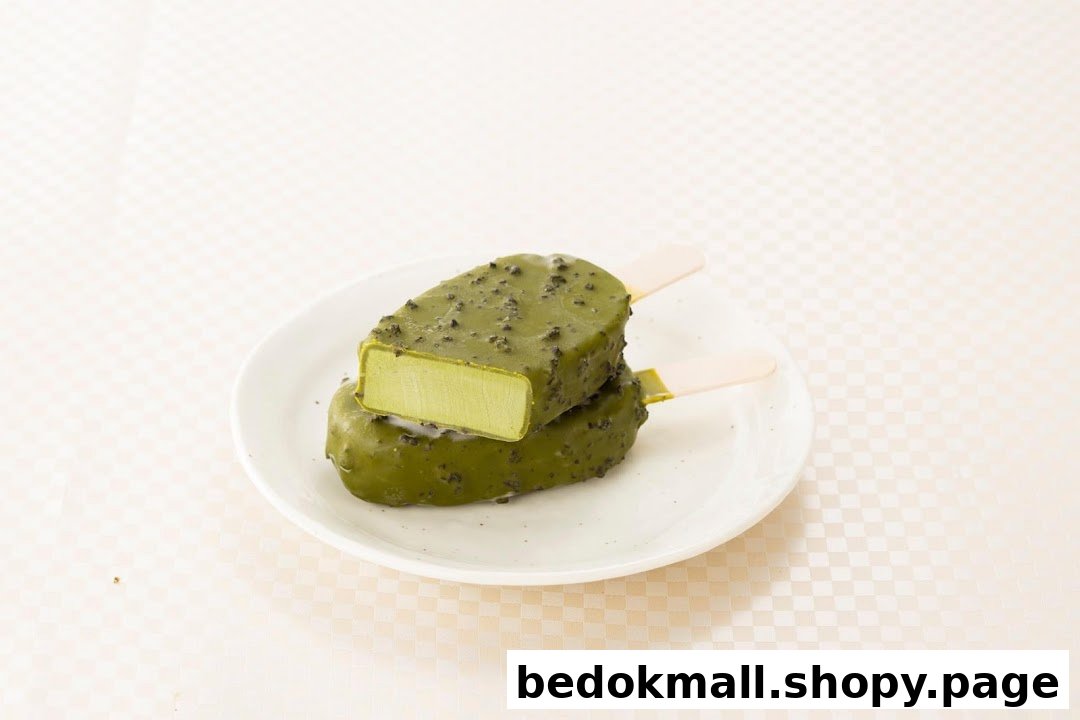 Two green ice cream bars on a white plate, one cut open.