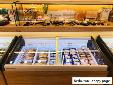 Interior view of a shop with refrigerated display cases and product models.