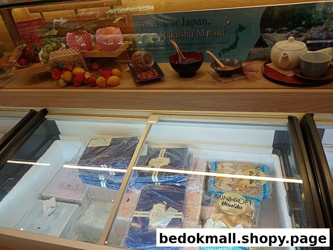 Interior view of a shop with a display case and freezer full of products.