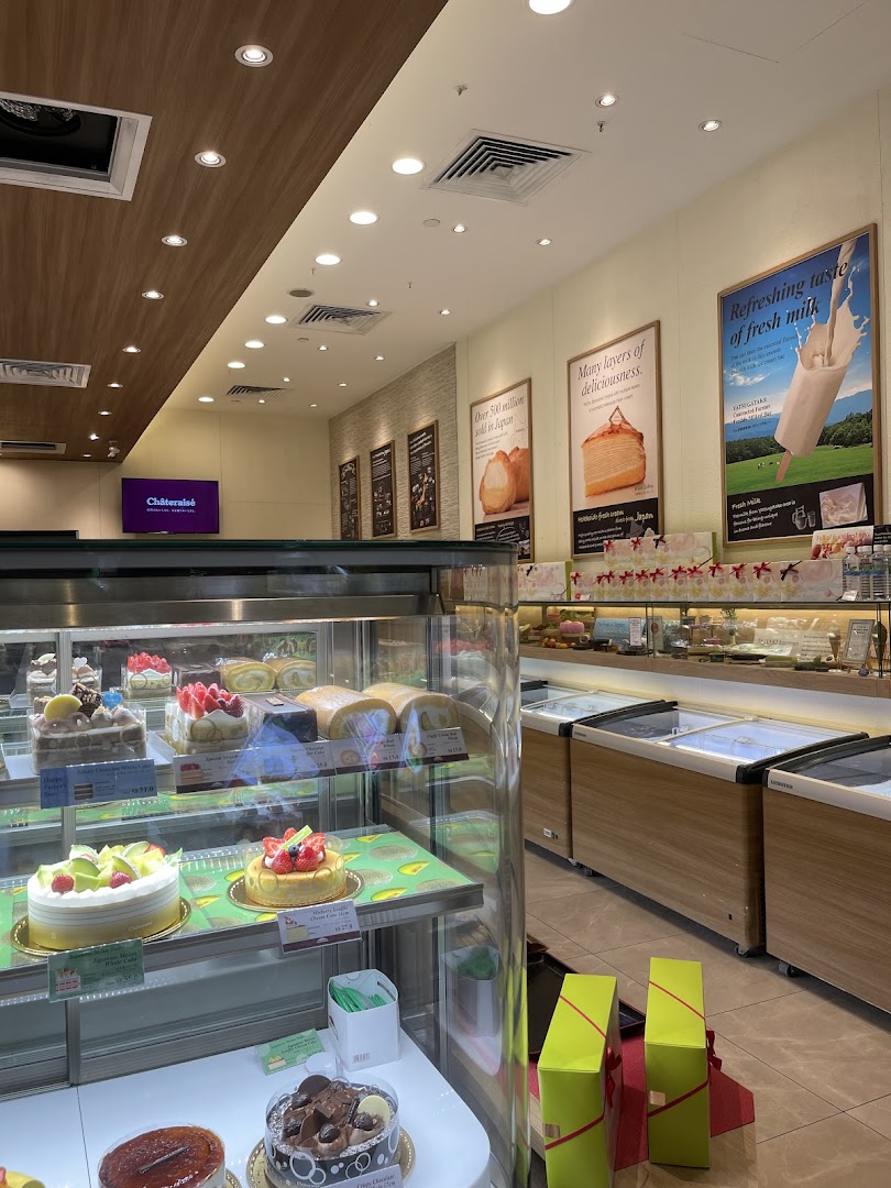 Interior view of a dessert shop with display cases of cakes and pastries.