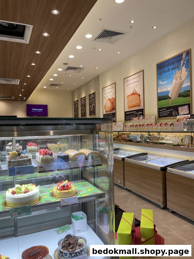 Interior view of a dessert shop with display cases of cakes and pastries.