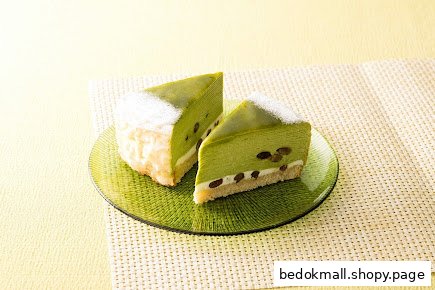 Two slices of green matcha cake with beans on a glass plate.