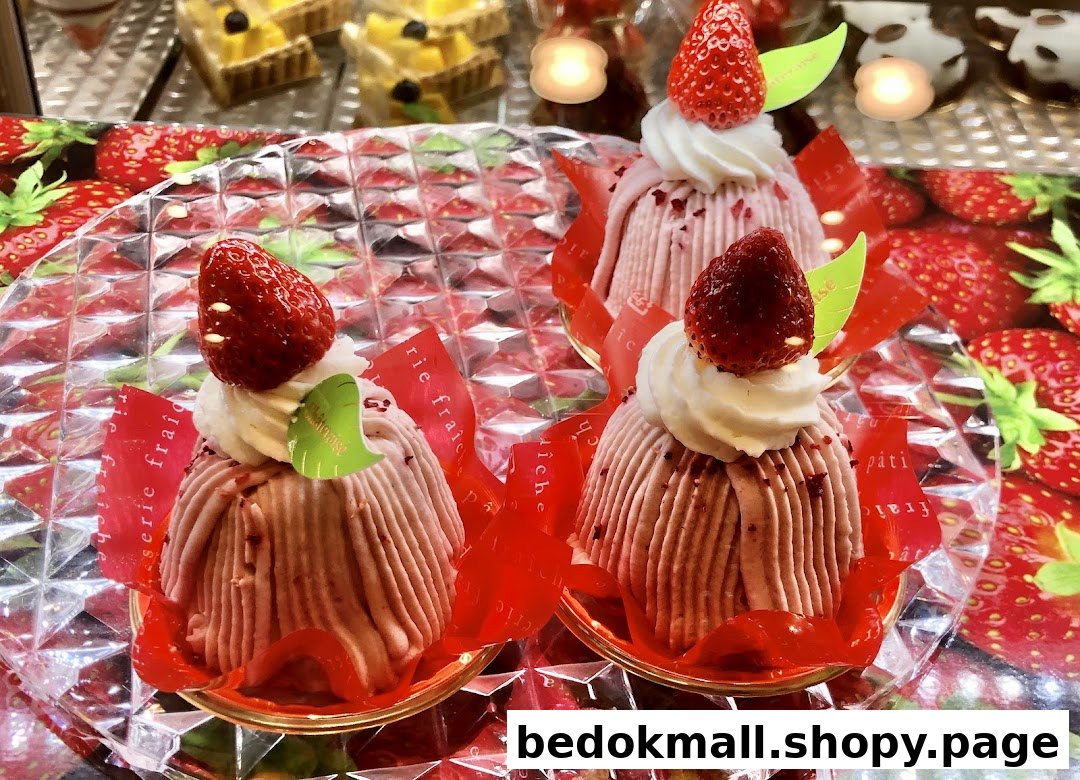 Three strawberry-topped pastries displayed on a clear tray.