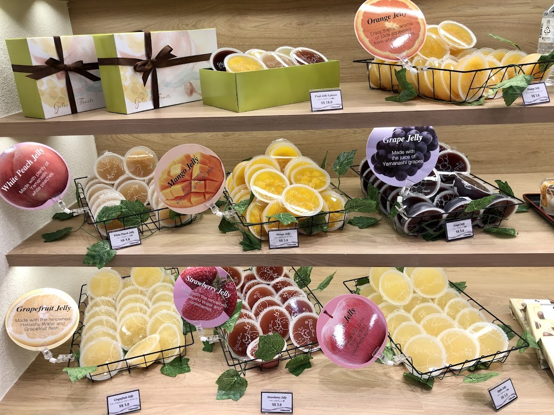 Display of various fruit jellies and gift boxes on shelves.