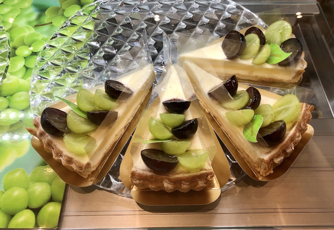 Slices of grape tart with green and purple grapes on display.