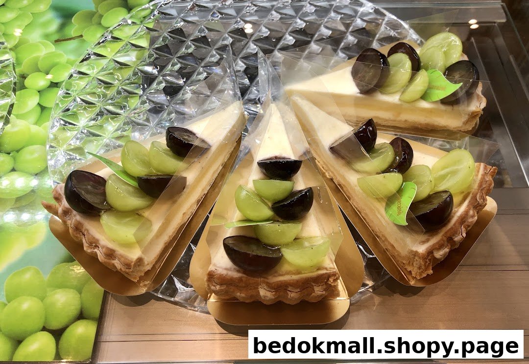 Slices of grape tart with green and purple grapes on display.