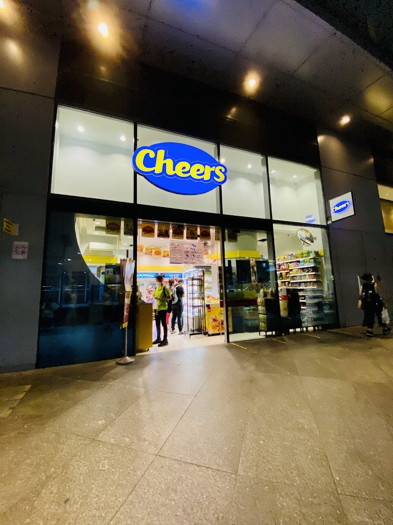 Exterior view of a brightly lit Cheers convenience store entrance at night.