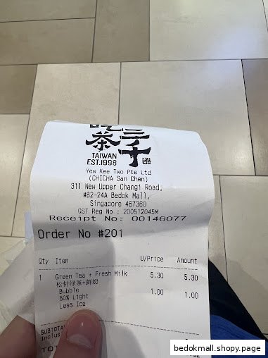 A hand holds a paper receipt from CHICHA San Chen showing an order.