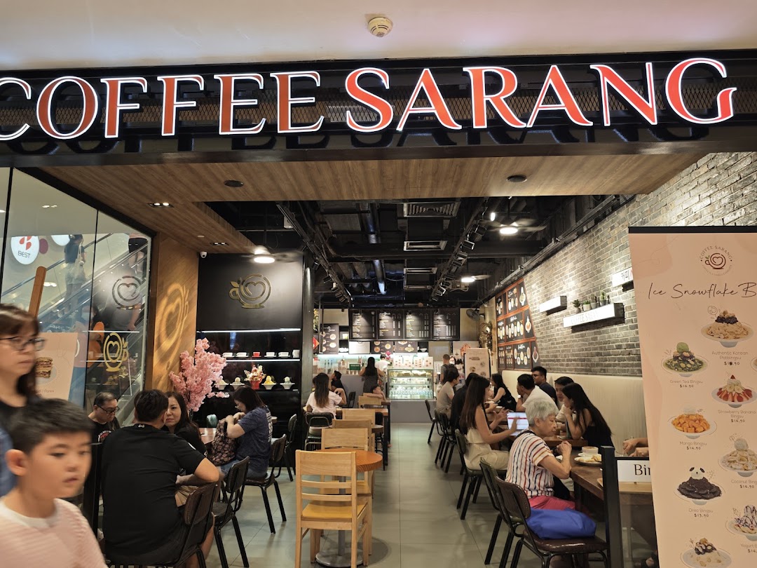 Interior view of a busy coffee shop with customers seated at tables.