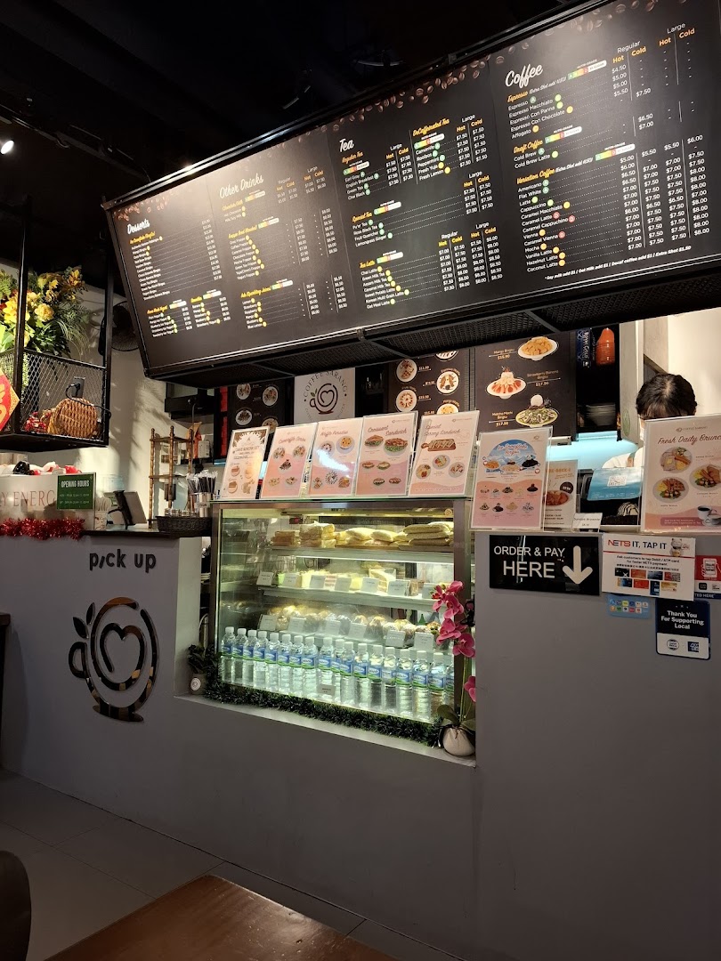 Interior view of a coffee shop counter with a large menu board and display case.
